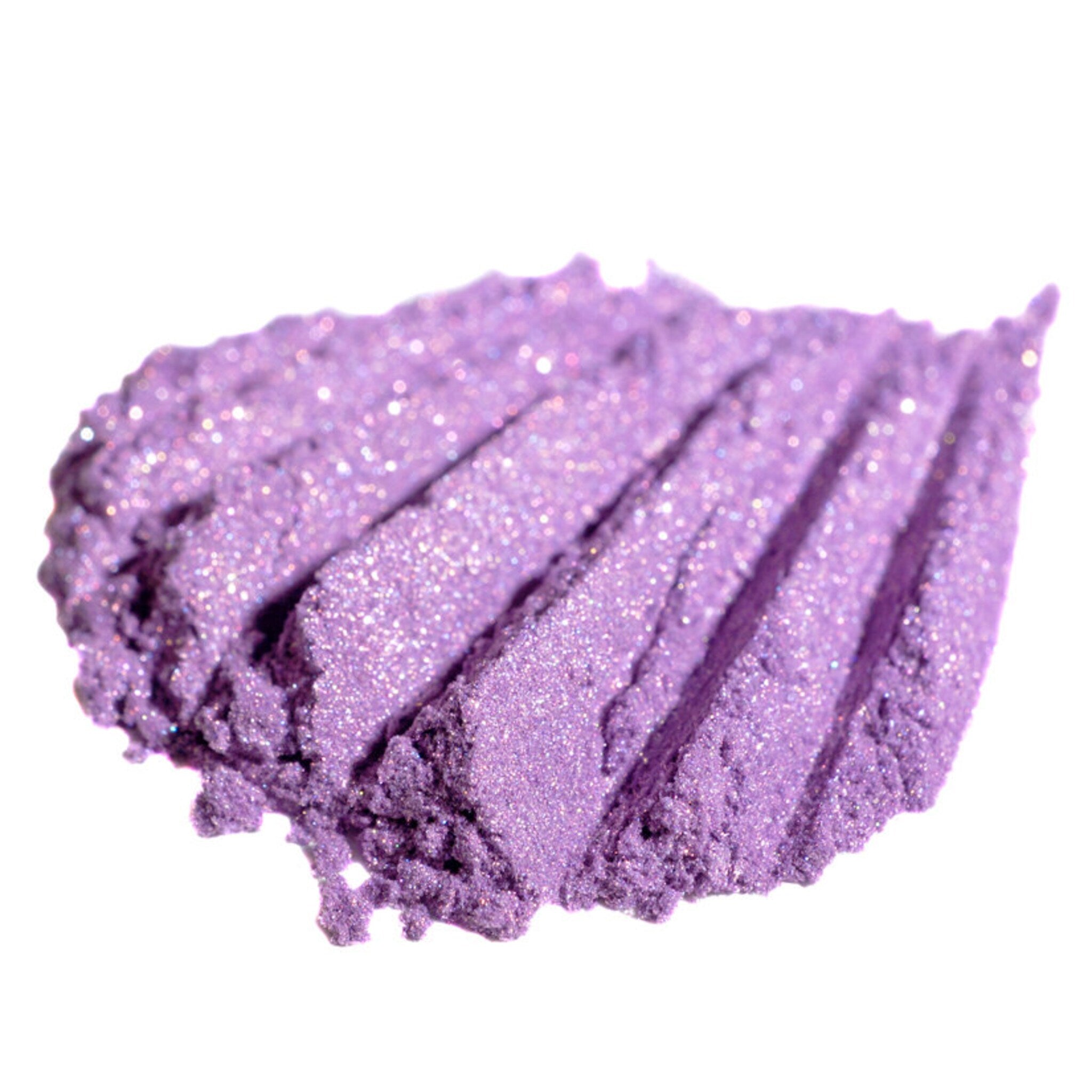 Purple eyeshadow swatch with glitter and textured finish on white background