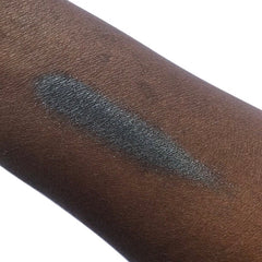Hand applying vegan black mineral eyeshadow with a blending brush for a smoky eye look