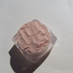 Close-up of loose mineral eyeshadow in frosty golden champagne with shimmering beige-brown particles