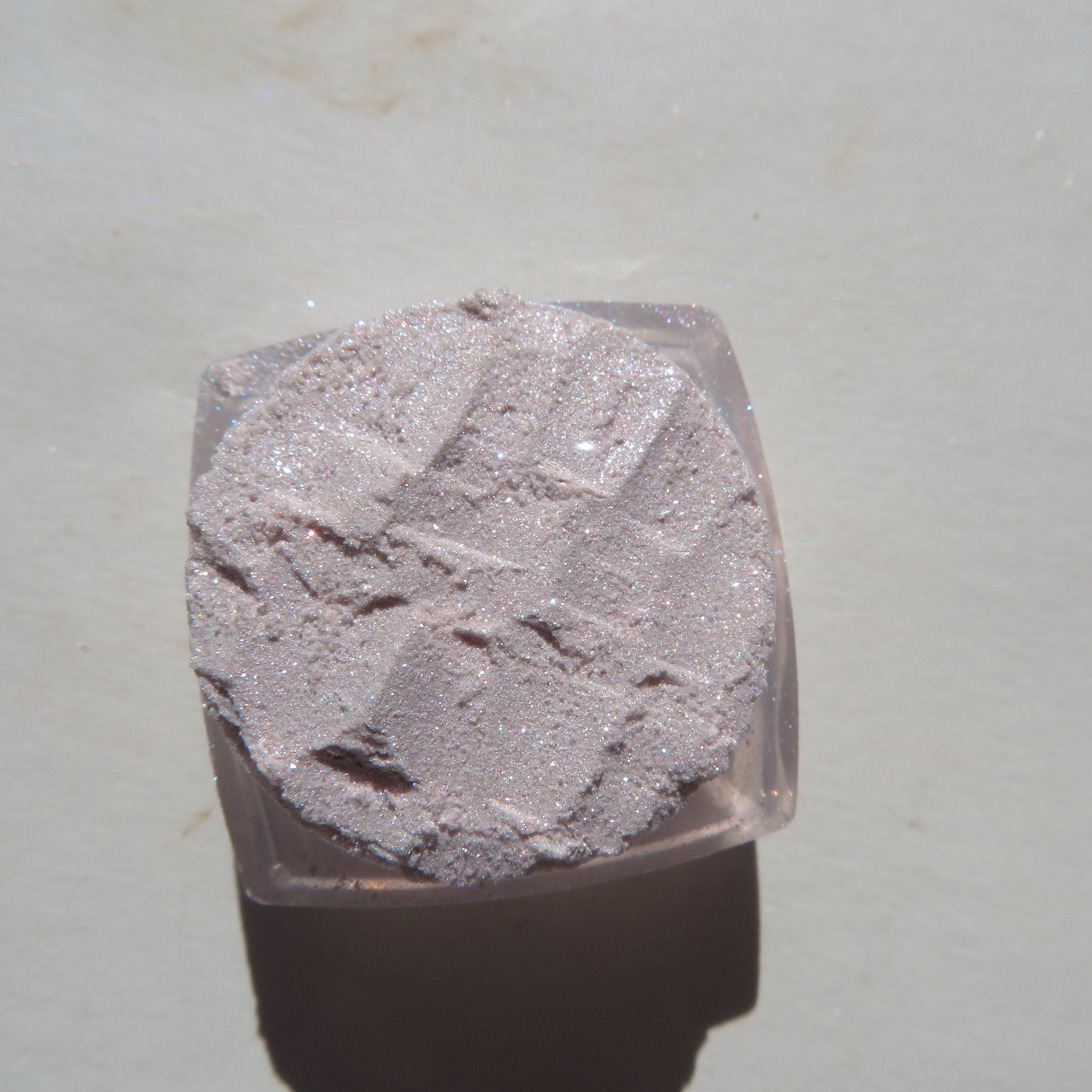Close-up of sheer pink sparkly glitter eye shadow with shimmering vegan mineral particles