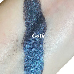 Close-up of dark navy blue eyeshadow with shimmering metallic luster in compact pan