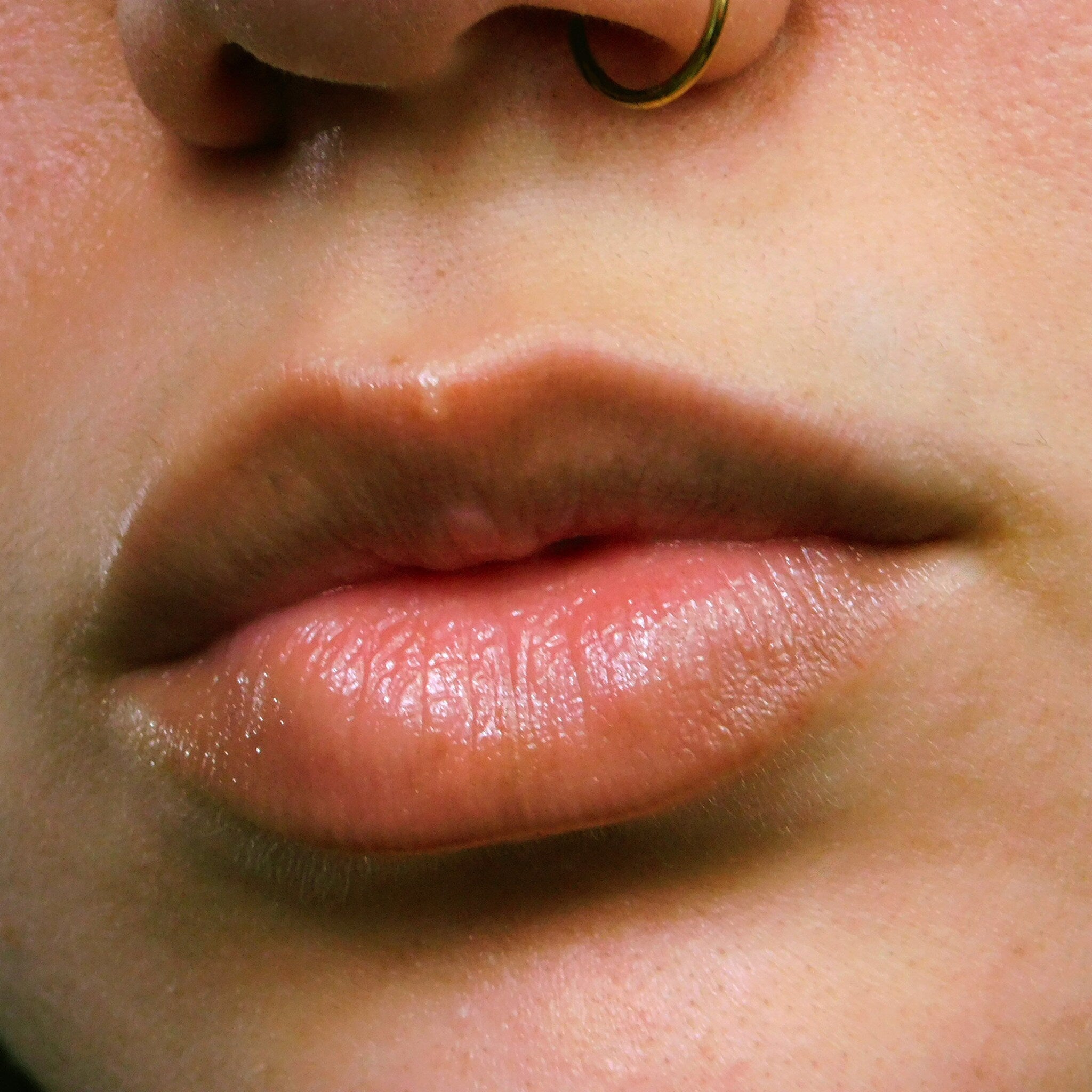 Lips close-up, pink skin, shiny texture, nose ring visible
