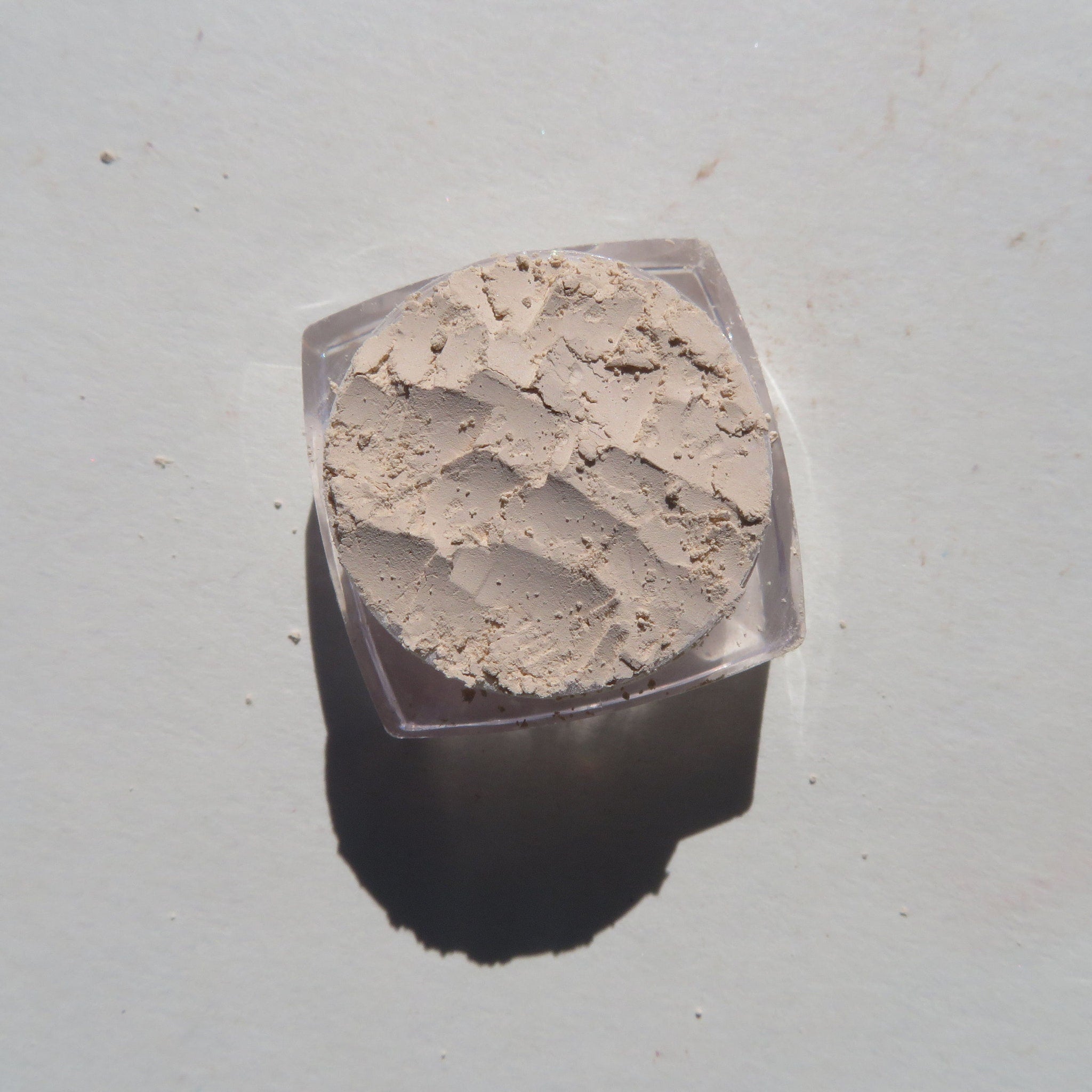 Close-up of creamy vanilla matte loose mineral eyeshadow with fine powder texture in eco-friendly packaging