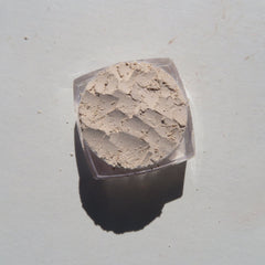 Close-up of creamy vanilla matte loose mineral eyeshadow with fine powder texture in eco-friendly packaging