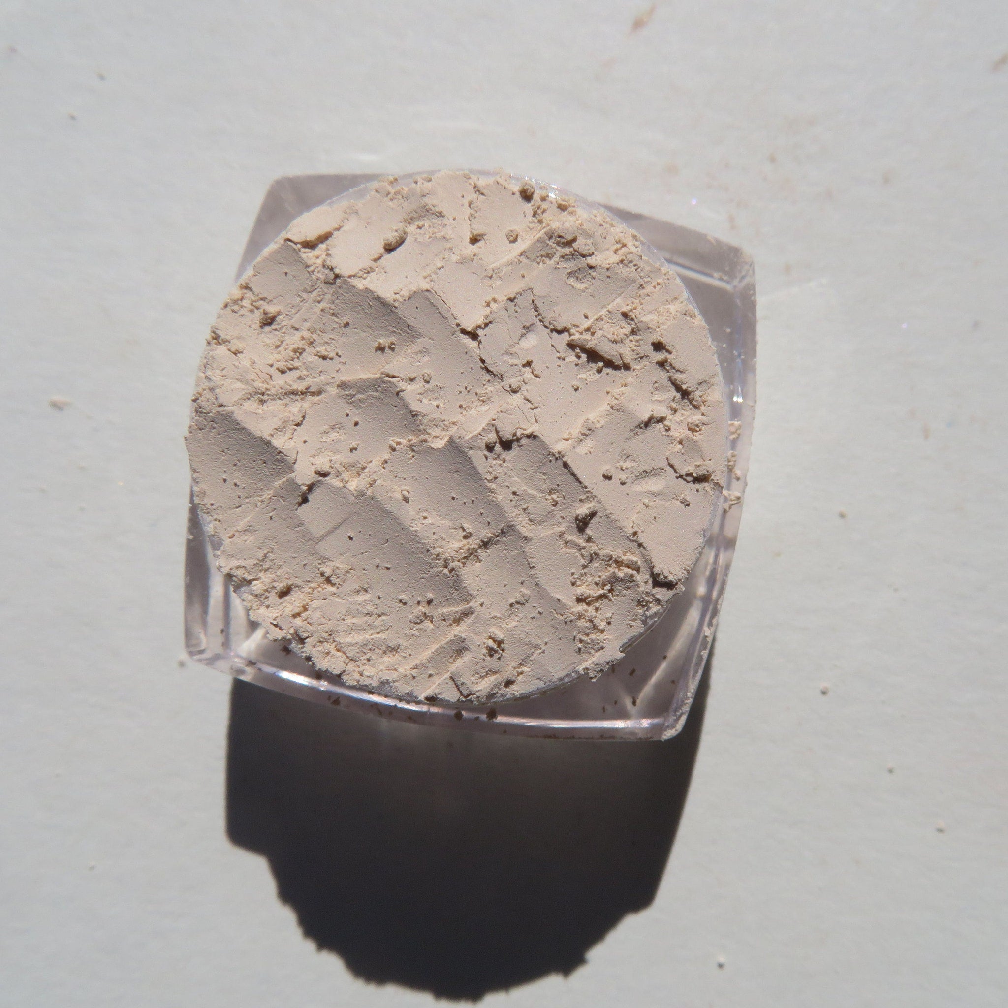 Hand applying creamy vanilla matte mineral eyeshadow with fingertip onto eyelid for soft neutral look