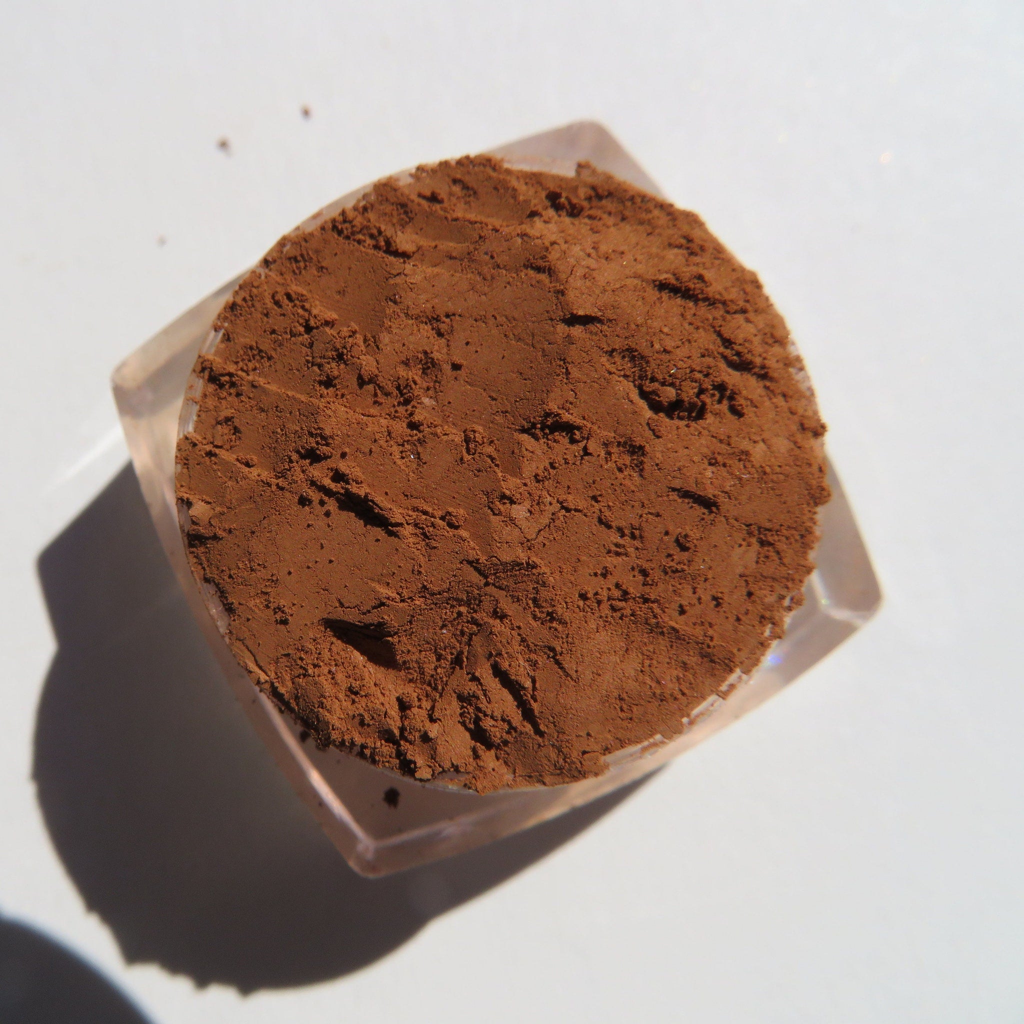 Side view of sandy brown loose mineral eyeshadow in matte gingerbread shade with vegan label visible