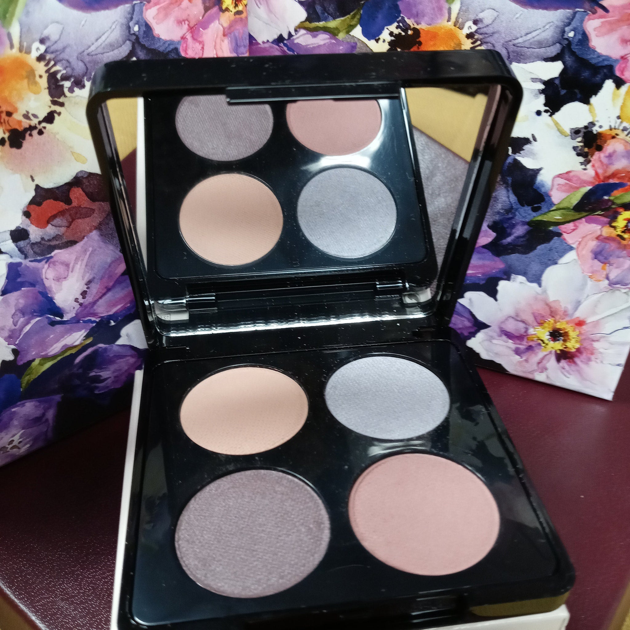 Side view of Merle Norman Eye Color Quad showing four pressed powder shadows in a sleek black compact