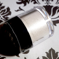 Pale ivory loose eyeshadow with silver and white shimmer glitter in a twist-top jar, vegan cosmetic product
