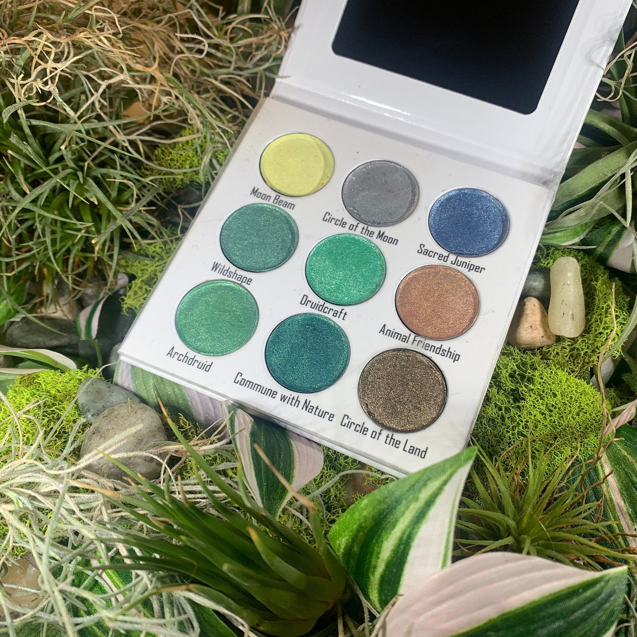 Close-up of D&D Druid Eyeshadow Palette showing matte forest green and shimmer gold shades with intricate Celtic designs