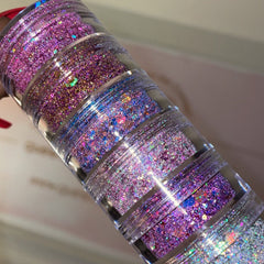 Hand applying iridescent chunky glitter eyeshadow to eyelid with fingertip, showcasing vibrant sparkle and texture
