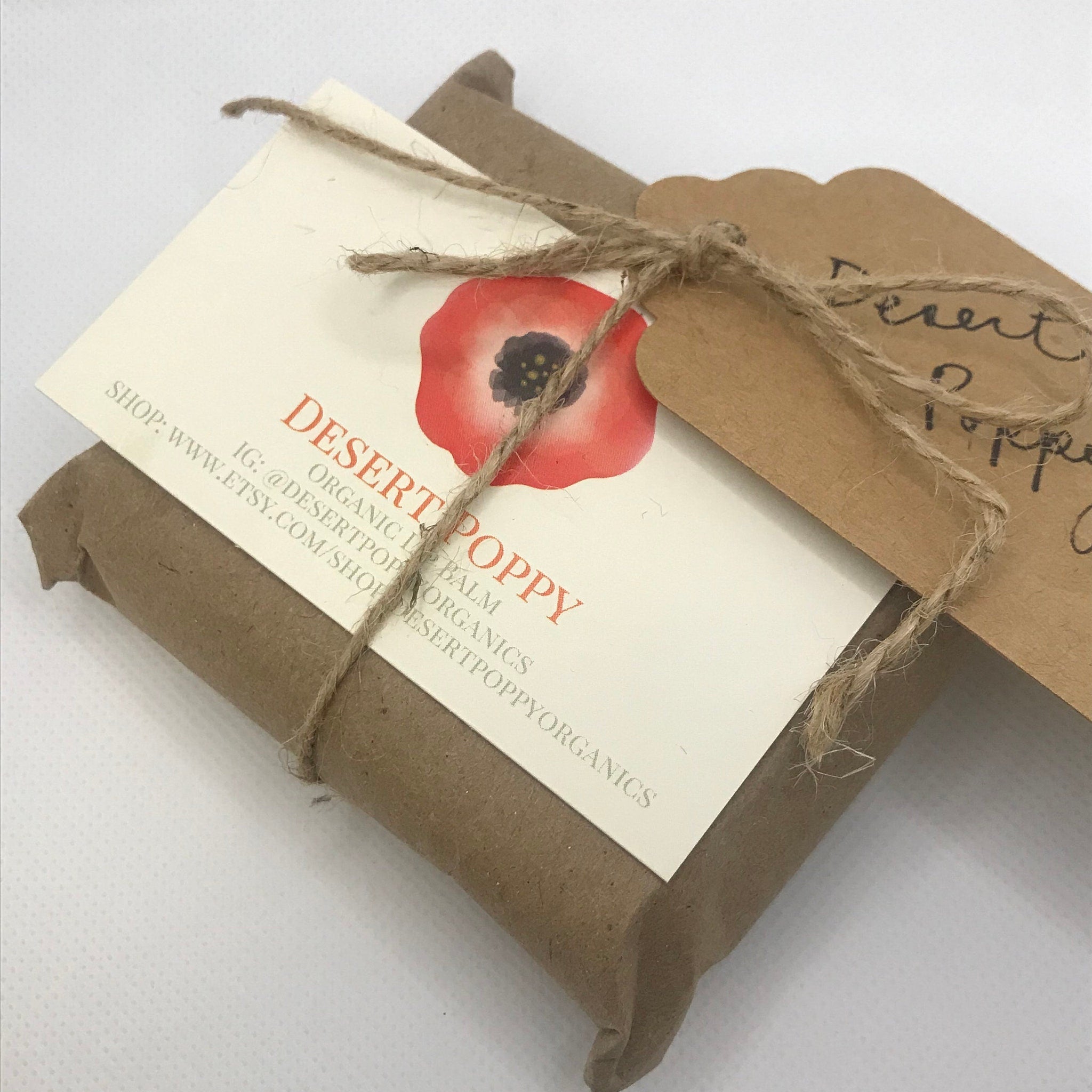 Desert Poppy lip balm wrapped in brown paper with twine and tags, Desert Poppy branding visible