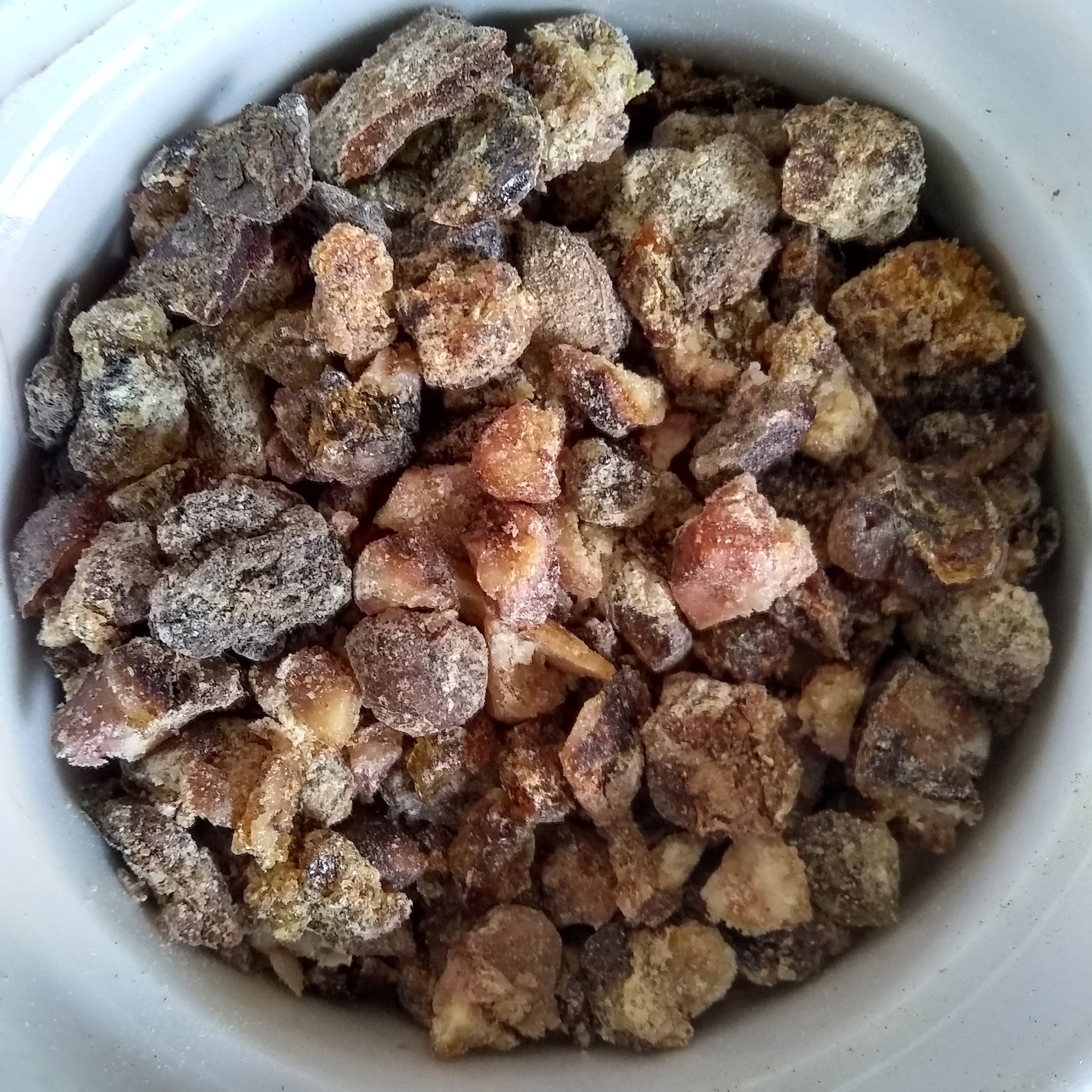 Granulated brown and tan pieces with a powdery coating in a white bowl