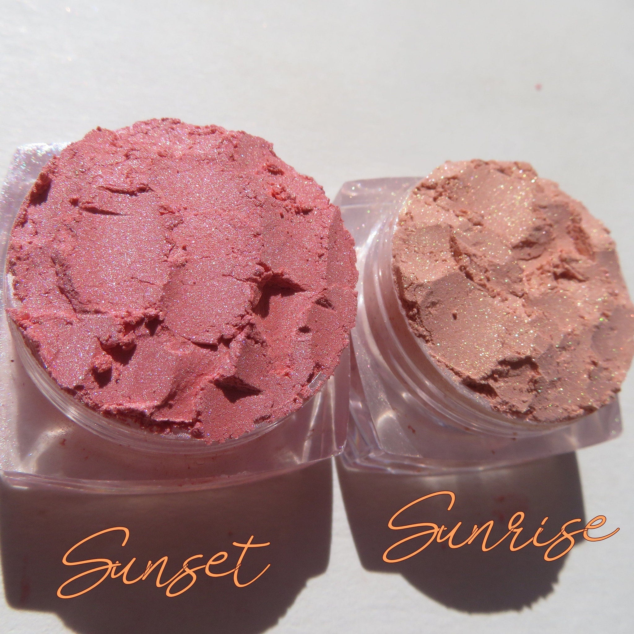 Close-up of loose Sunset Orange shimmer eyeshadow pigment with metallic flecks in a glass jar