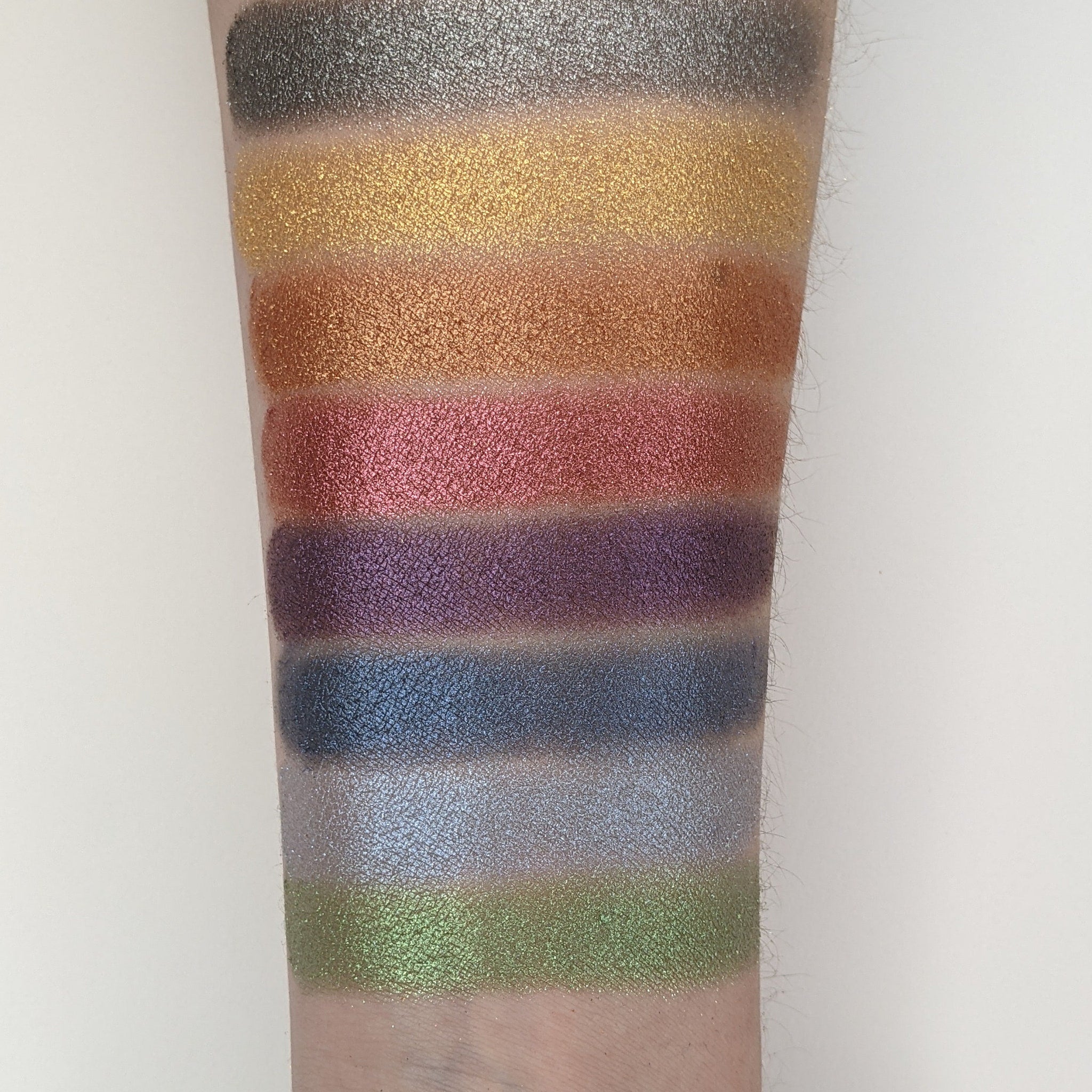 Side view of Vegan Churro Bronze Shimmer Pressed Eyeshadow pan showing warm bronze tones and reflective shimmer particles