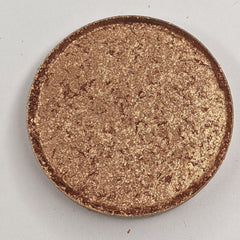 Bronze shimmer pressed eyeshadow in round compact with vegan label, showcasing warm metallic finish