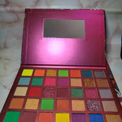 Side view of MI CORAZON eyeshadow palette displaying matte and shimmer shades in warm neutrals and bold hues