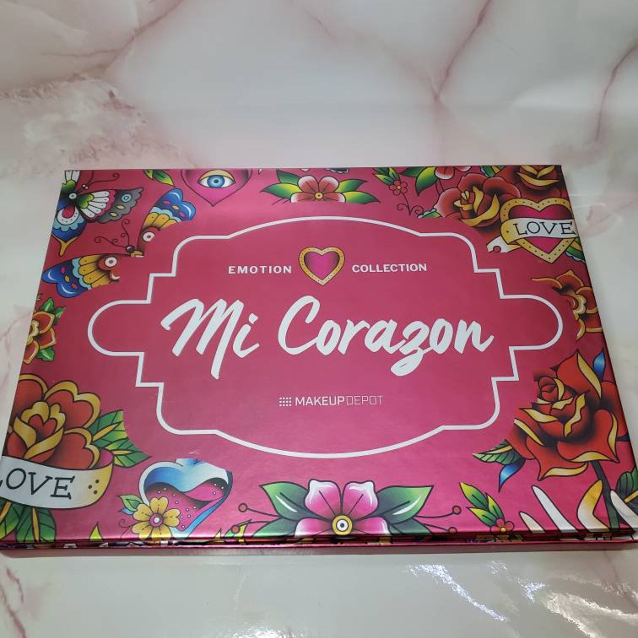 MI CORAZON eyeshadow palette with matte and shimmer shades in warm neutrals and bold brights, rectangular compact