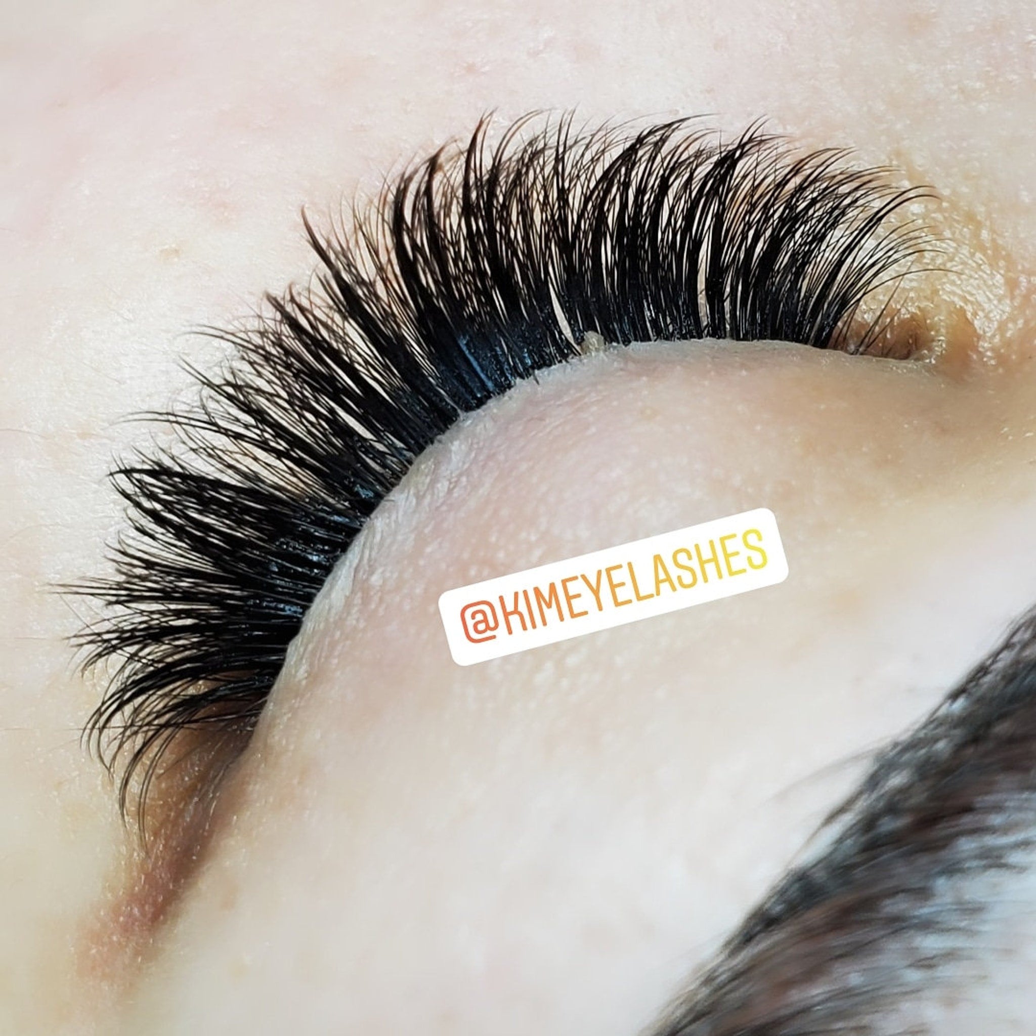 Eyelash extensions, black, curved, dense lashes with @KIMEYELASHES branding visible