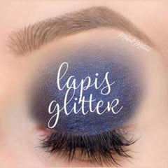 Eye makeup with blue glitter and white script "lapis glitter" over the eye, visible eyelashes