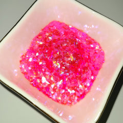 Pink glitter in a pink square dish with gold trim, close-up shot