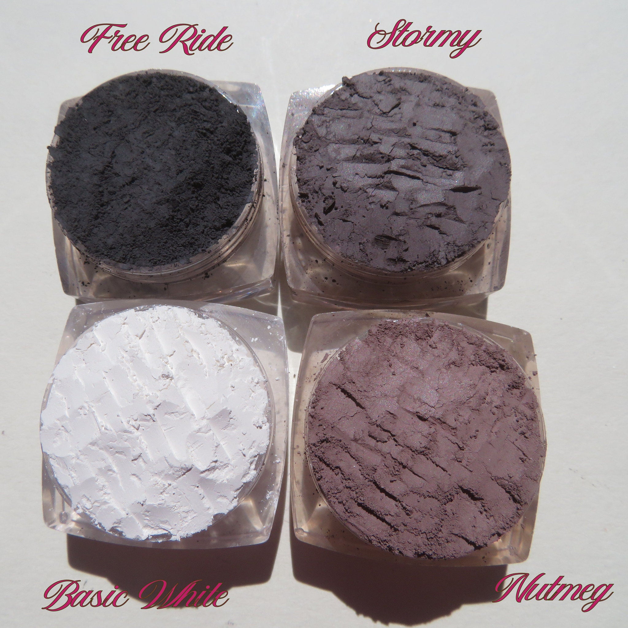 Square gift box with four loose mineral eyeshadows in earthy tones, tied with a satin ribbon