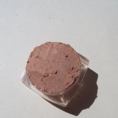 Side view of matte brown loose mineral eyeshadow in a sifter jar with vegan and cruelty-free label visible