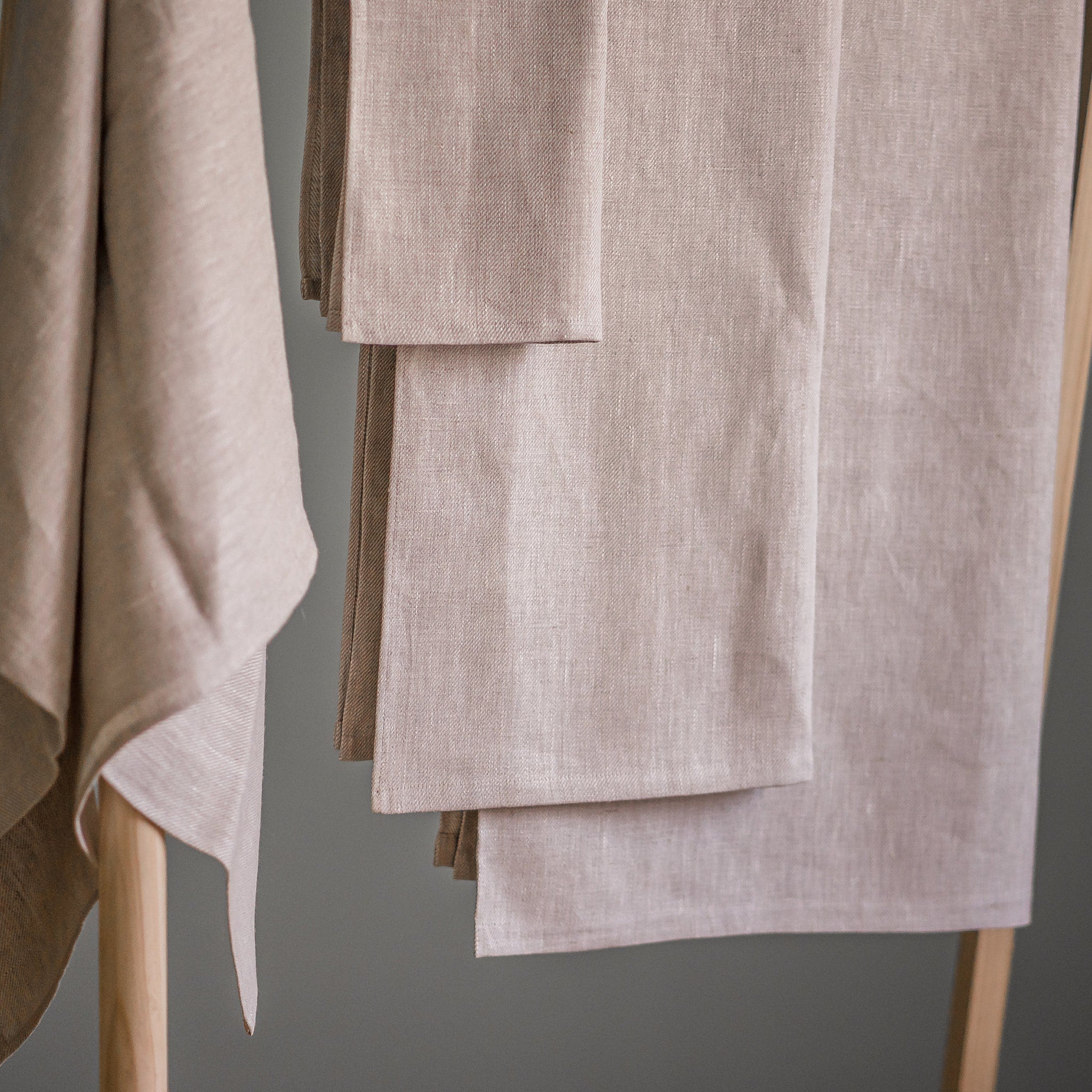 Linen napkins, beige color, woven texture, folded on a wooden rack