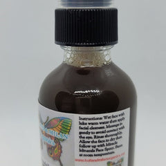 Facial cleanser bottle with black cap and brown liquid, Holland & Milan Organics label visible