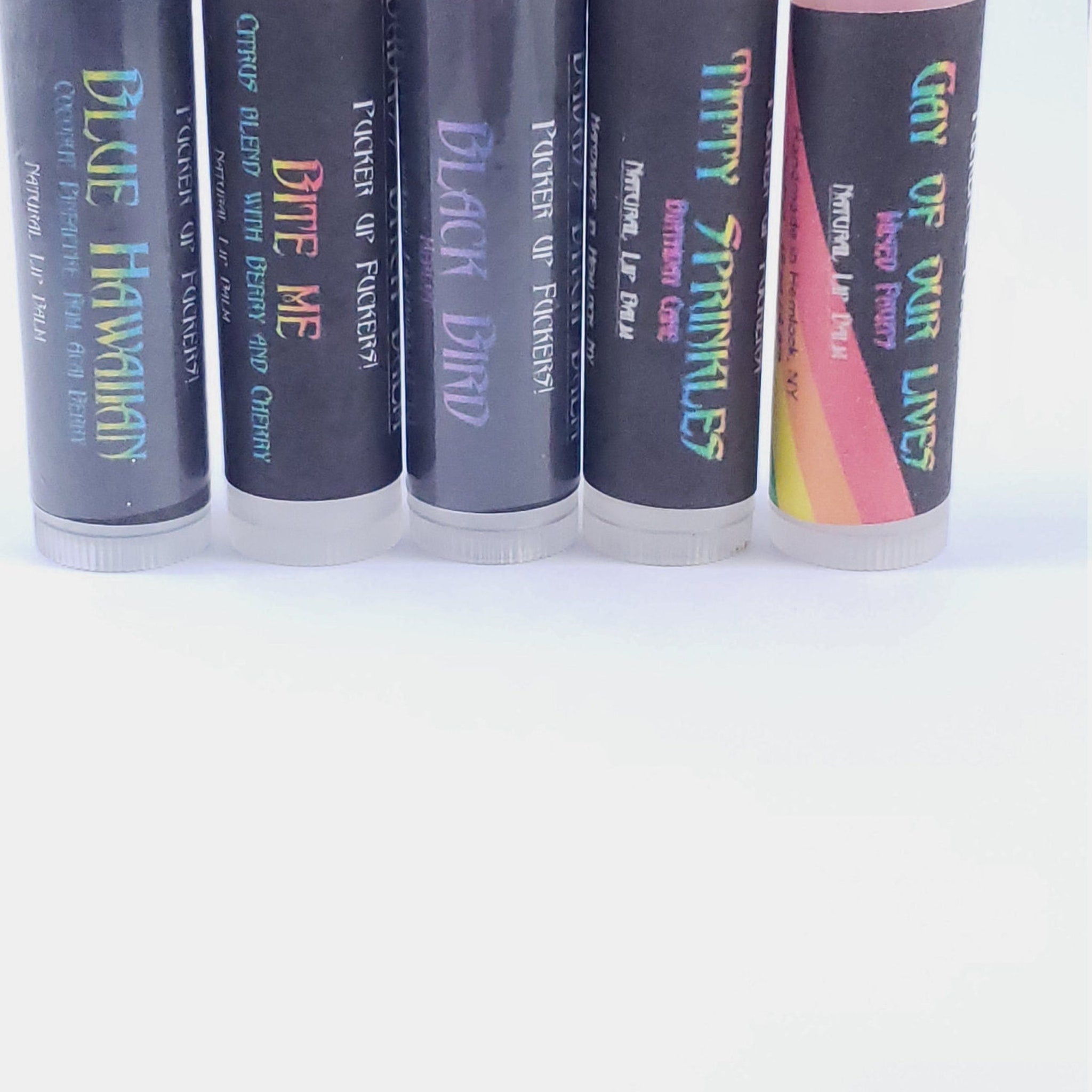 Lip balm tubes with black, holographic text and white base, various flavors visible