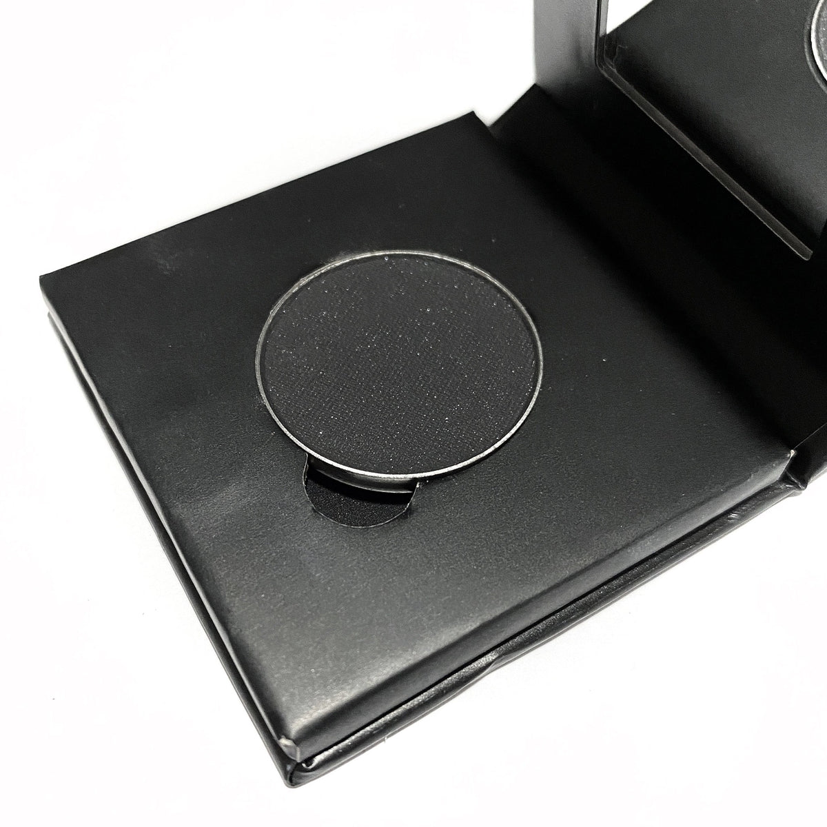 Jet black mineral eye shadow in a square paperboard compact with matte finish and silver brand logo