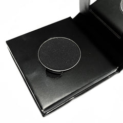 Close-up of matte black pressed mineral eyeshadow with smooth, velvety texture in compact case