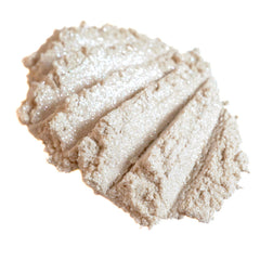 Close-up of loose vanilla ivory eyeshadow with silver and white shimmer glitter particles