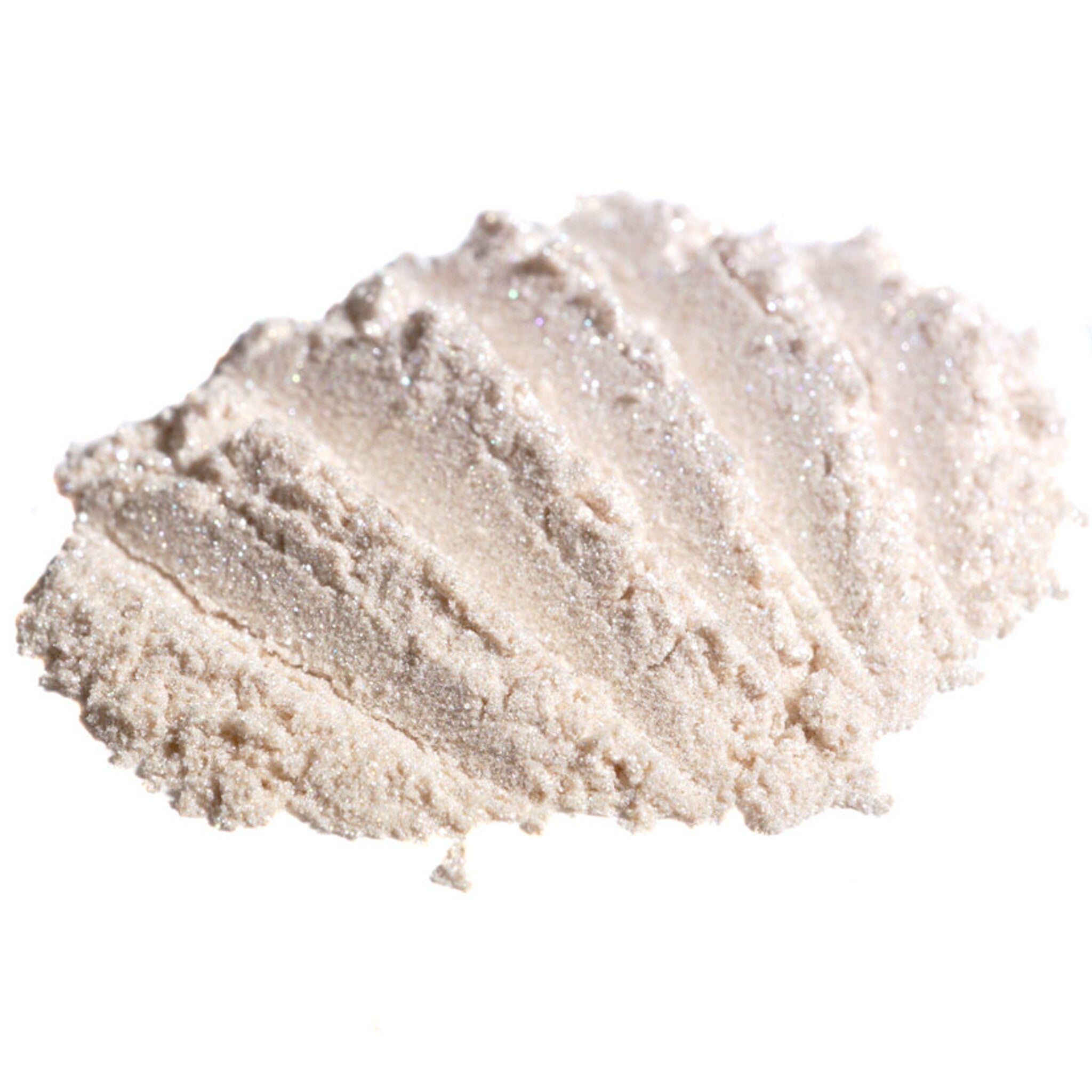 Hand applying shimmering vanilla ivory loose eyeshadow with silver-white glitter using a makeup brush