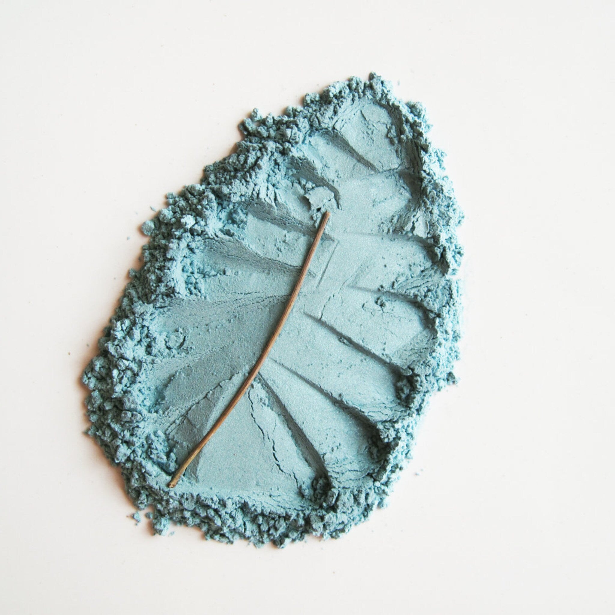 Close-up of Pure & Natural Capri Mineral Eye Shadow in a round compact with shimmering blue-green powder