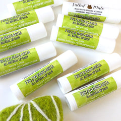 Lip balm tubes with white and green labels, text "Frozen Margarita" and "Salted Mute" brand