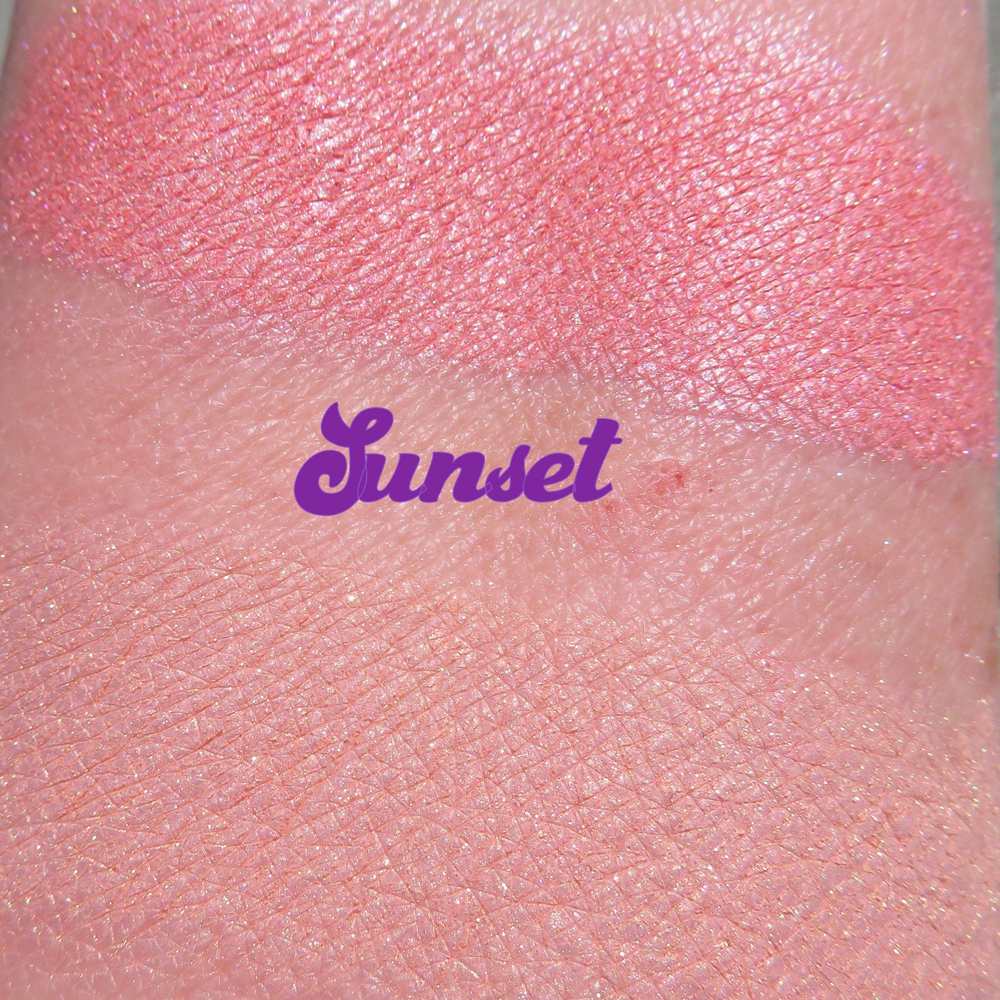Side view of loose Sunset Orange shimmer eyeshadow powder spilling from jar, showcasing vibrant pigment and fine texture