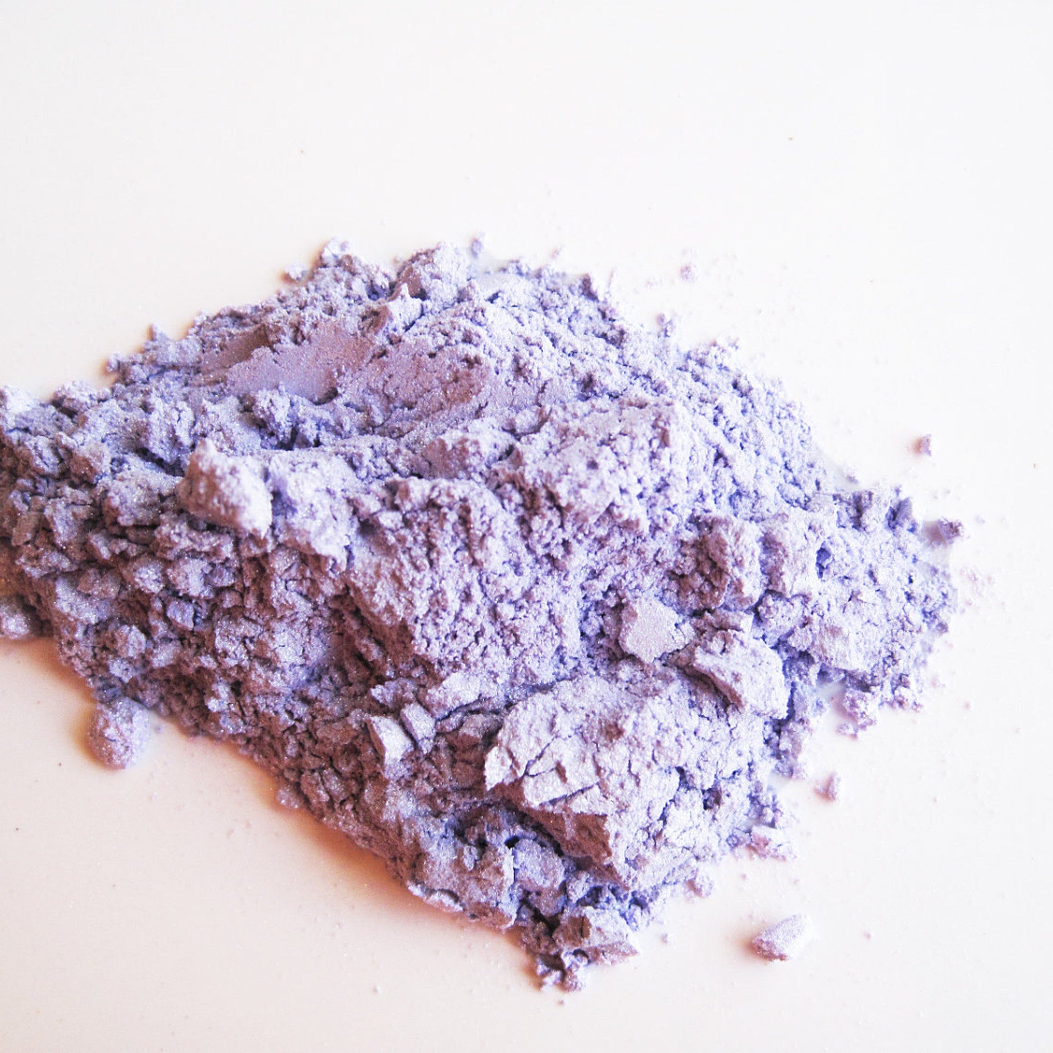 Close-up of Candied Violet mineral eye shadow showing soft purple shimmer and finely milled powder texture