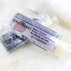 Lip balm tubes with strawberry label, clear plastic, and BlackroseKraftwork branding