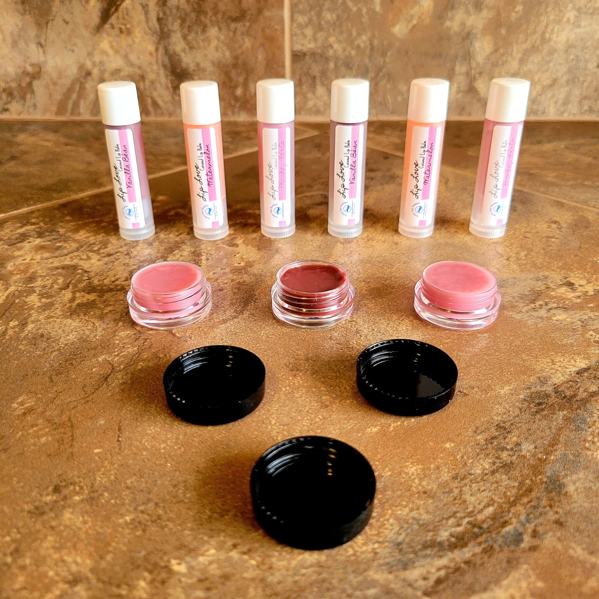 Lip balm tubes with white caps, pink labels, and clear containers, with Lip Love text visible