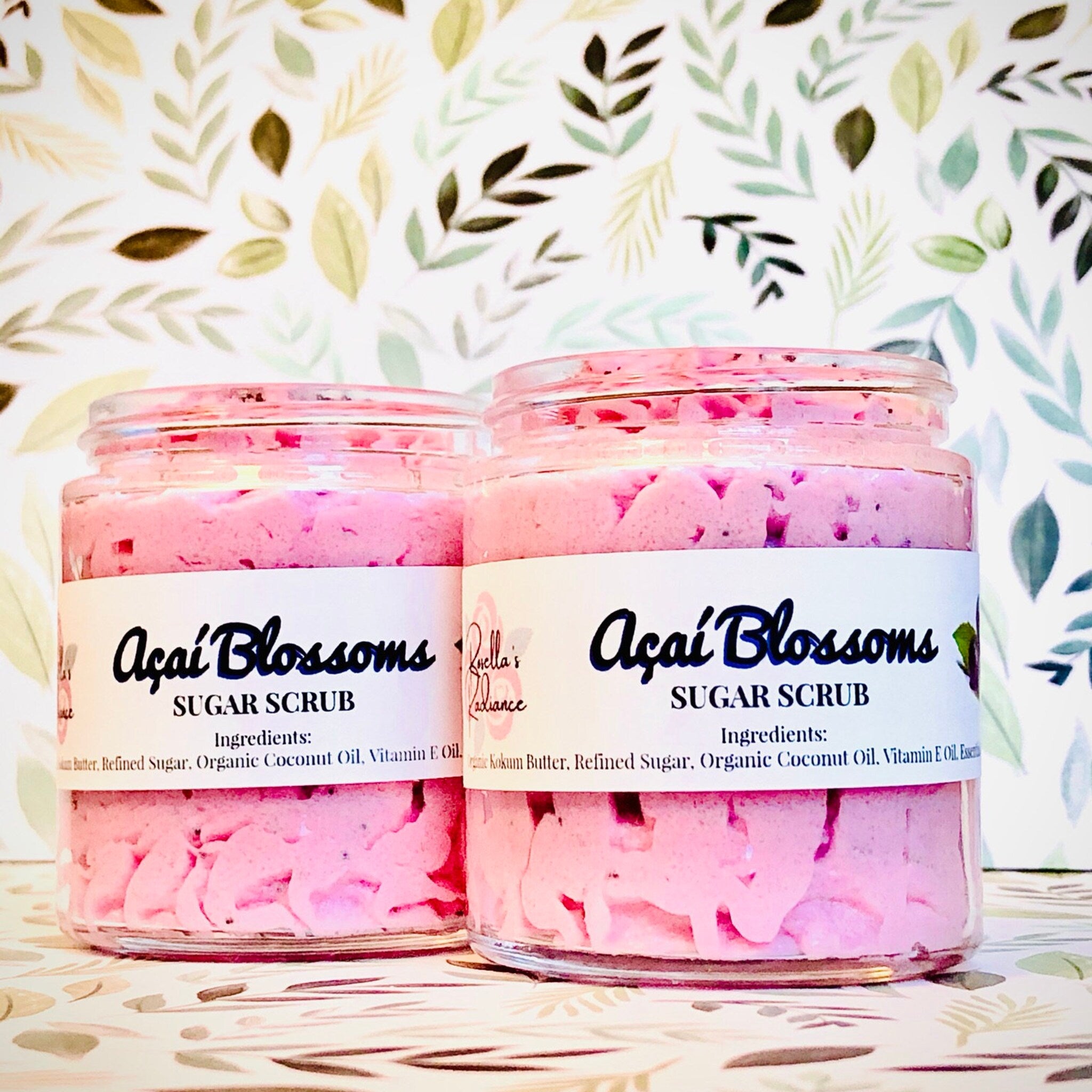 Sugar scrub jars with pink scrub, clear glass, and white labels with text