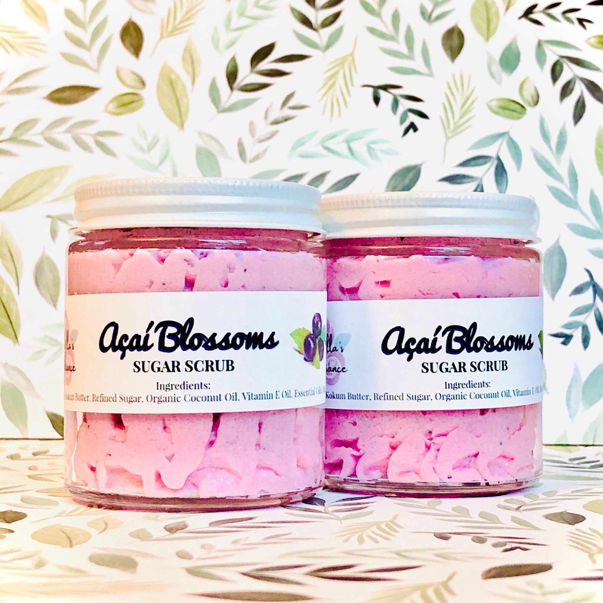 Sugar scrub jars with pink scrub, white lids, and "Açai Blossoms" label text