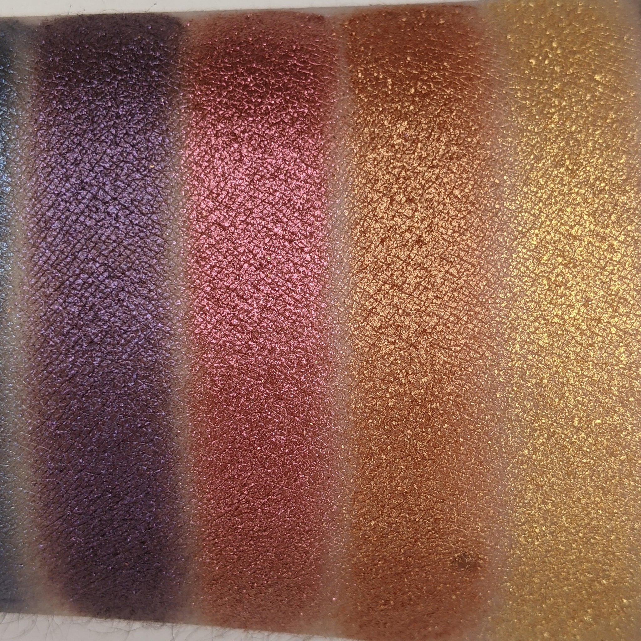 Bronze shimmer eyeshadow compact with vegan label, displayed open on marble surface