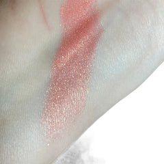 Close-up of pink coral shimmer eye shadow with natural glitter particles in sifter jar
