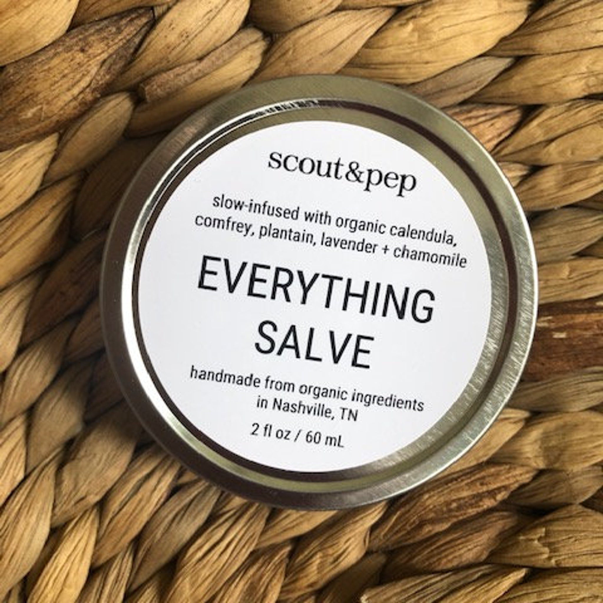 Salve tin with white label, silver rim, and woven brown background, Scout & Pep brand