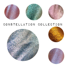 Close-up of multichrome pressed eyeshadow pans with shimmery sparkle and color-shifting hues in celestial-inspired shades