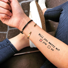 Set of temporary 'Will You Marry Me' tattoo stickers in delicate script on clear backing, skincare-safe adhesive