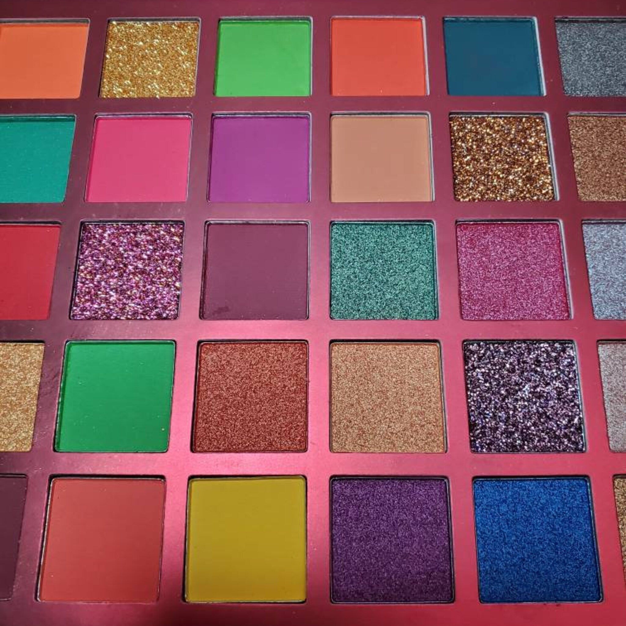 Side view of MI CORAZON eyeshadow palette showing matte and shimmer shades in a sleek black compact