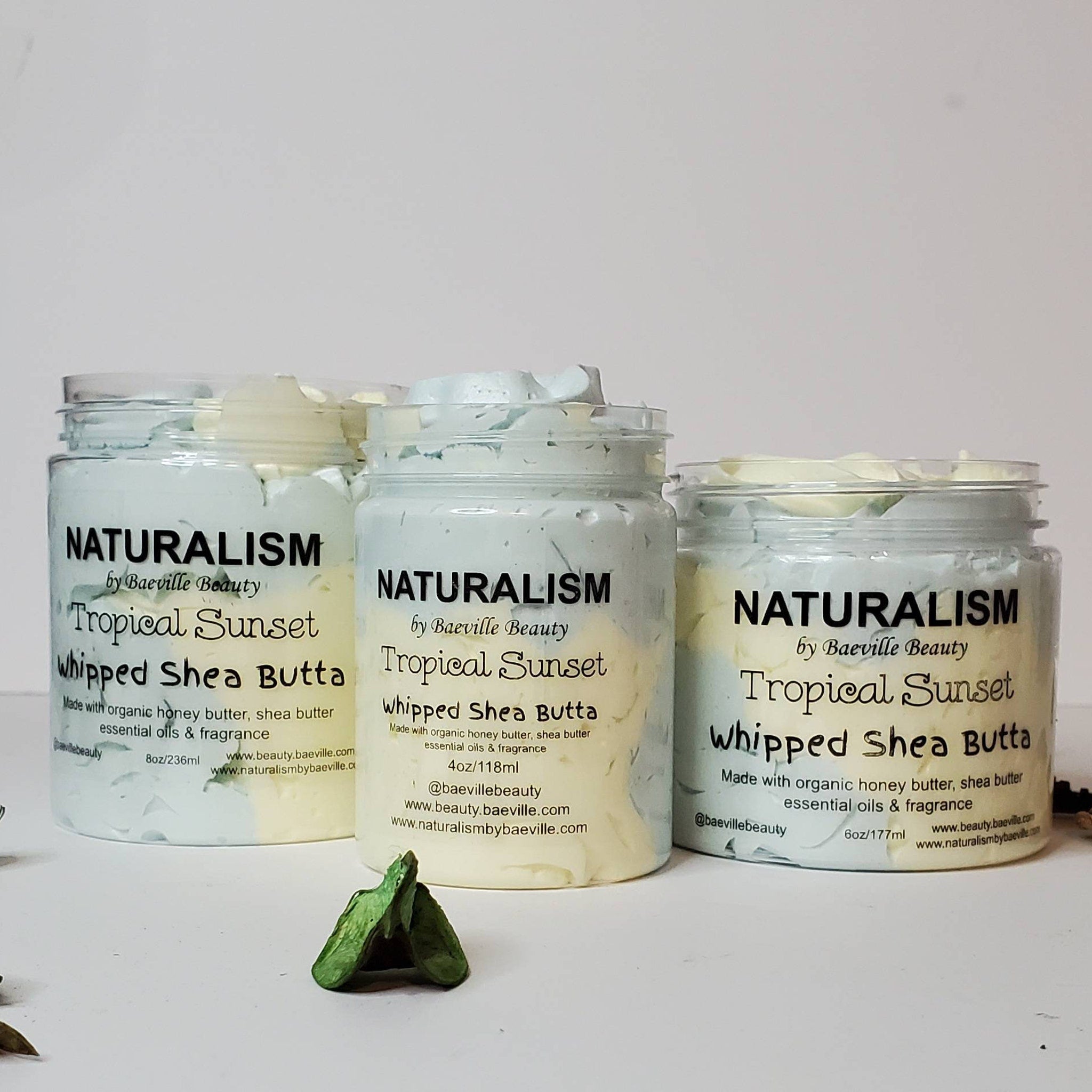 Whipped shea butter jars with blue and yellow swirls, clear plastic, Baeville brand text visible