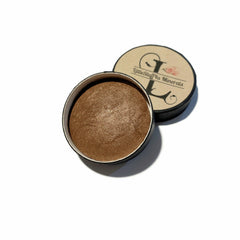 Side view of baked brindle brown eyeshadow pan showing textured surface and warm bronze undertones