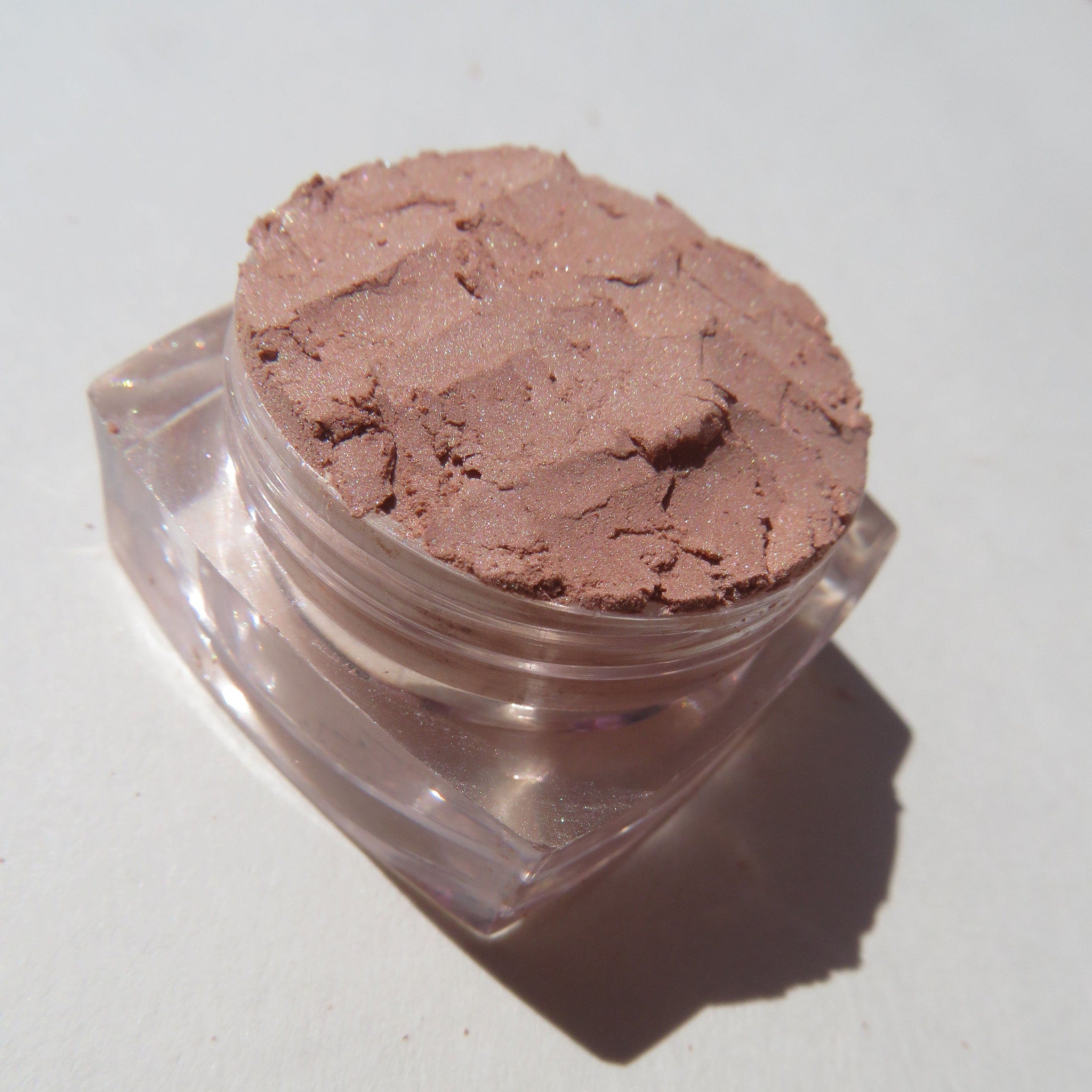 Side view of matte brown loose mineral eyeshadow in a sifter jar, showcasing rich coffee latte pigment texture.